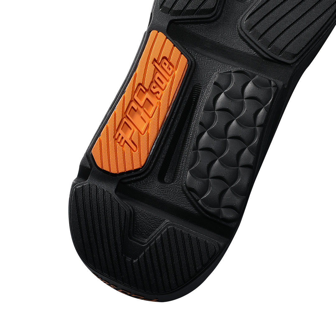 Close-up of a black athletic shoe sole with a bright orange accent panel featuring the embossed brand name 'PCSsole'.