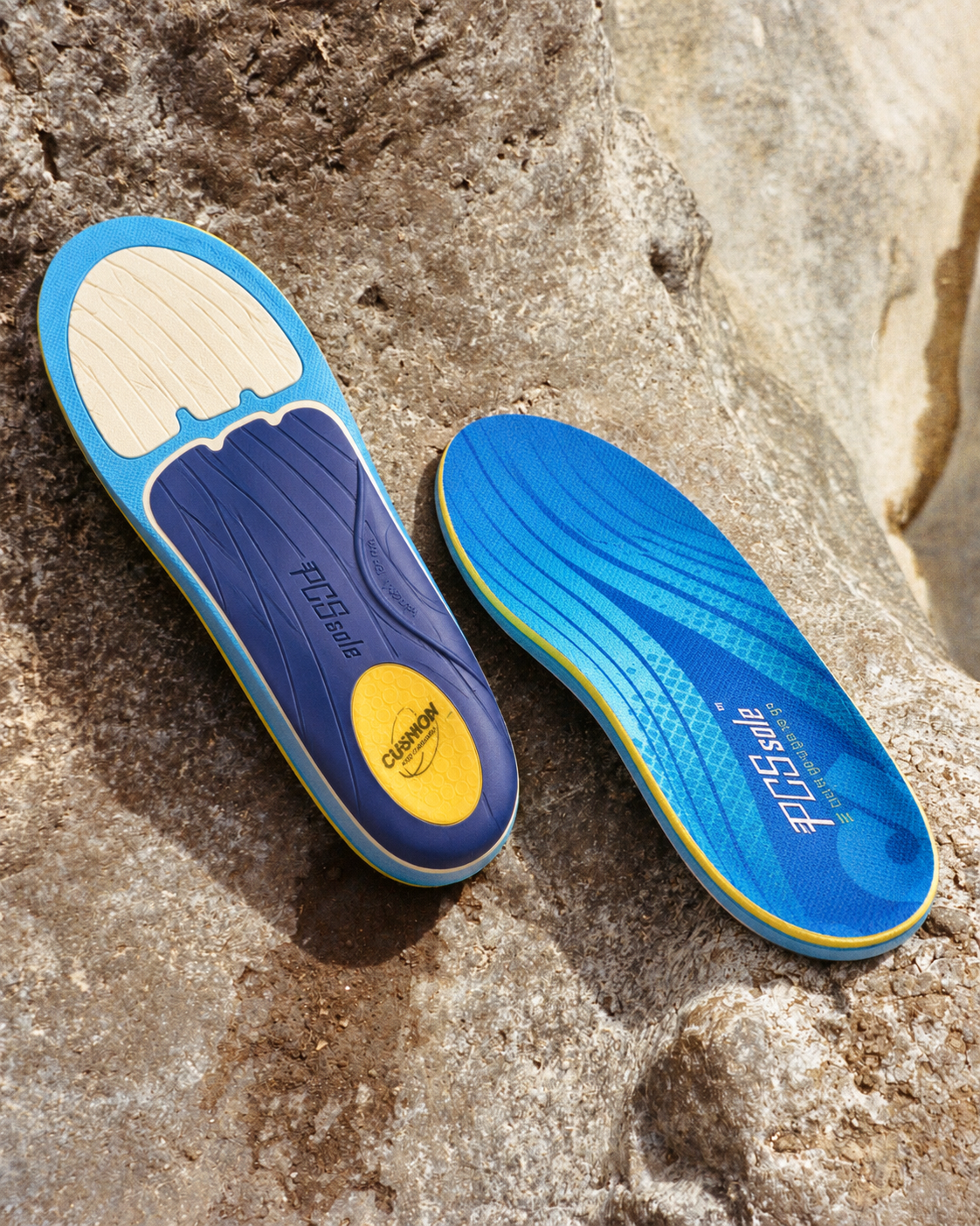 Two custom orthopedic shoe insoles displayed on a natural rock surface.