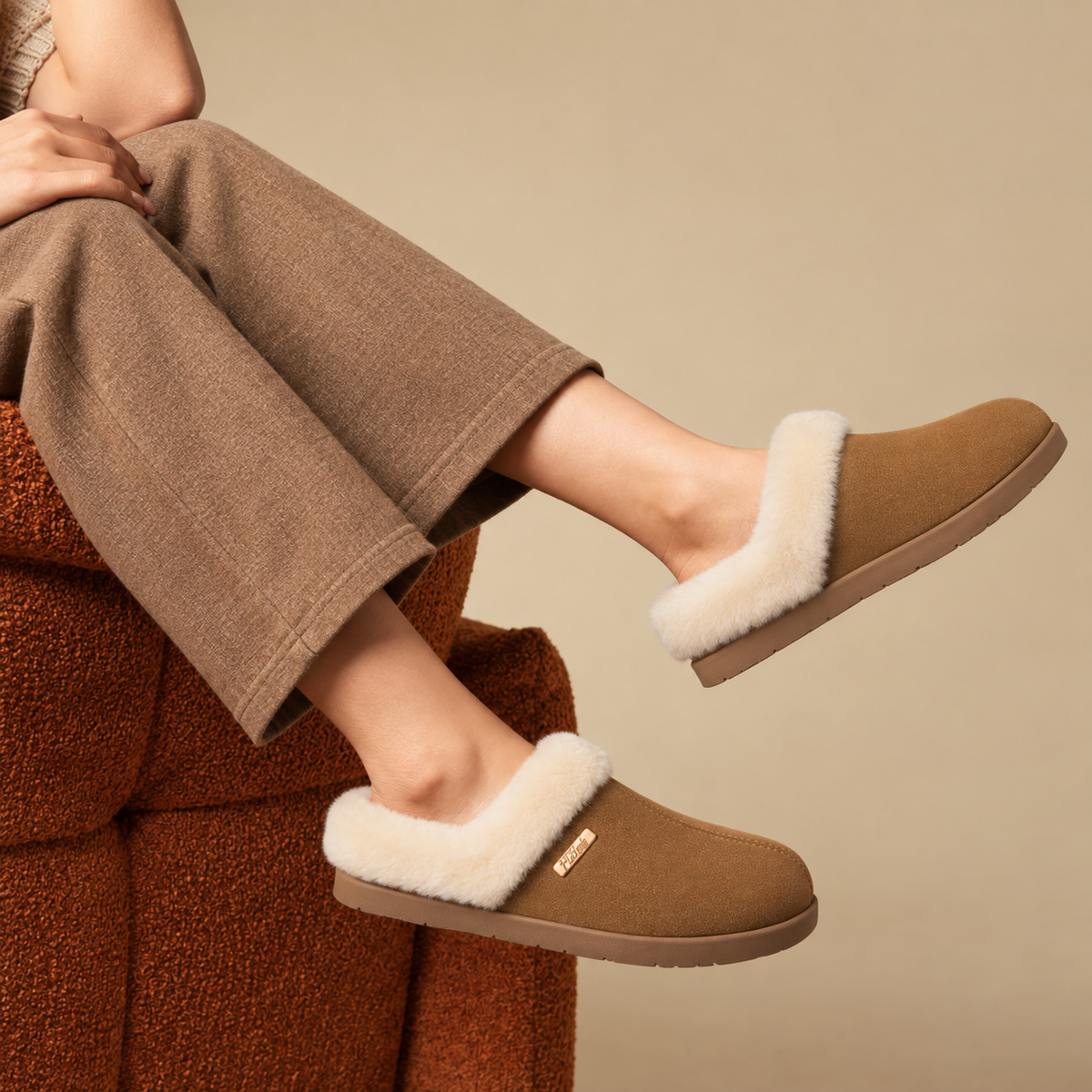 A woman wearing PCSsole brown suede slip-on slippers 