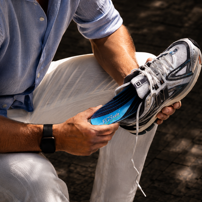 Man holding a running shoe with a focus on the PCSsole arch support insoles